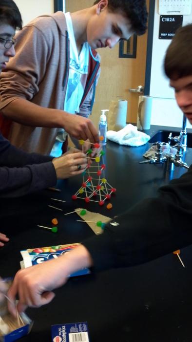 A student building a small tower model.